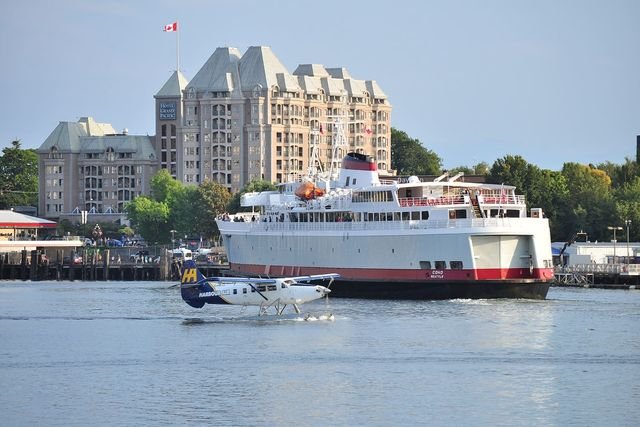 A Harbour Air floatplane on the water beside the MV Coho in Victoria